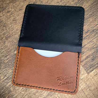 Black and brown leather wallet on a wooden surface